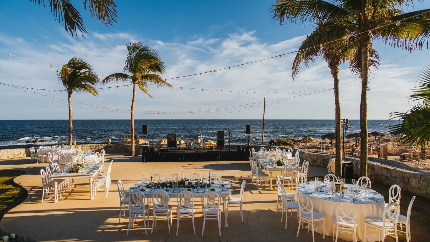 Beachside event setup with tables in overlooking the ocean near Grand Fiesta Americana