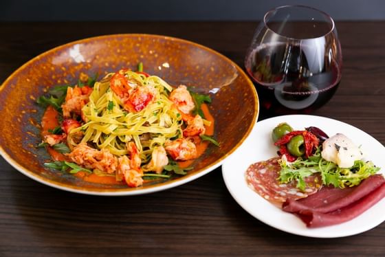 Prawn Linguine and meat served with wine in Cena Ristorante at Chateaux Deer Valley
