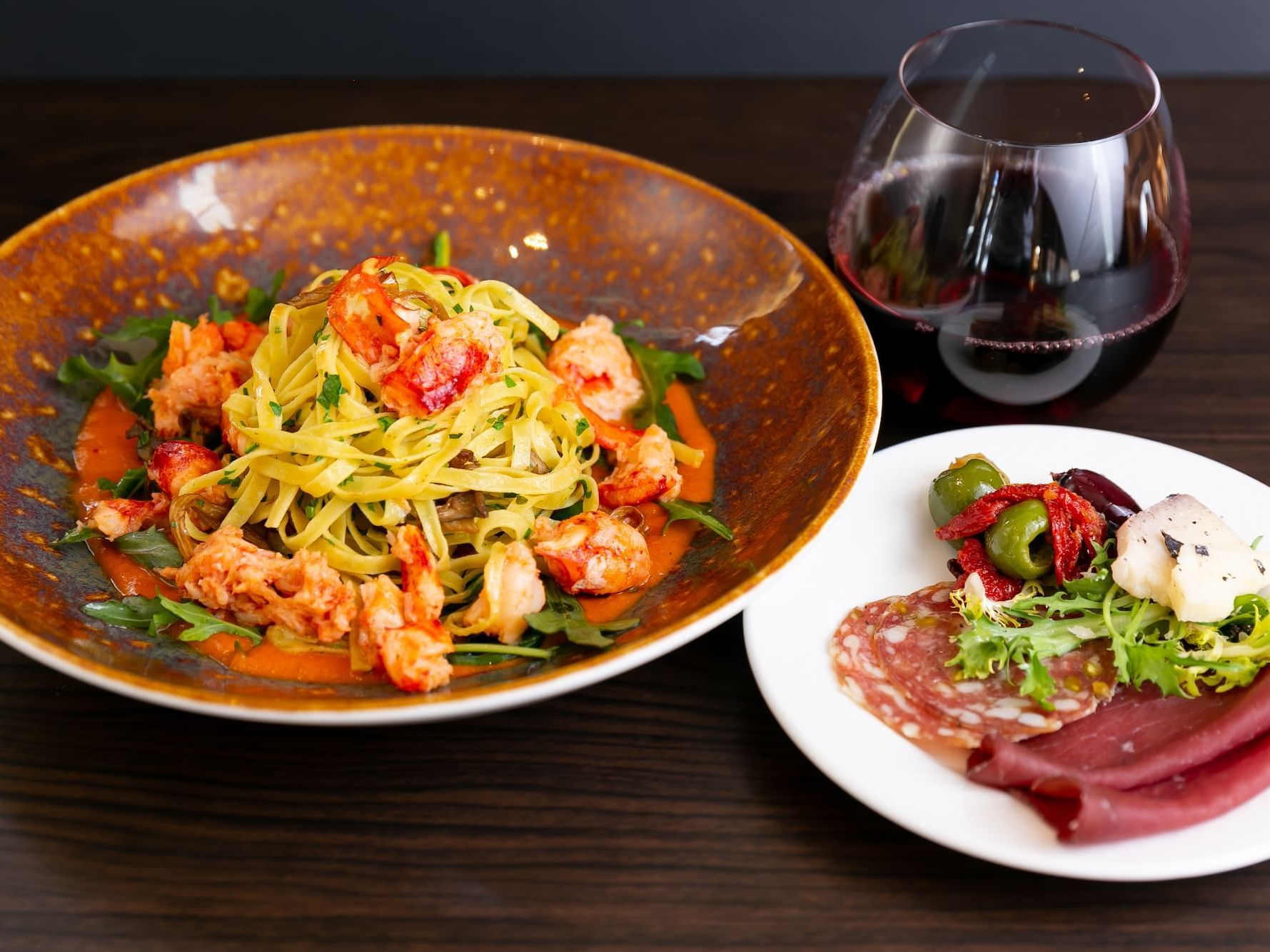 Prawn Linguine and meat served with wine in Cena Restaurant at Chateaux Deer Valley