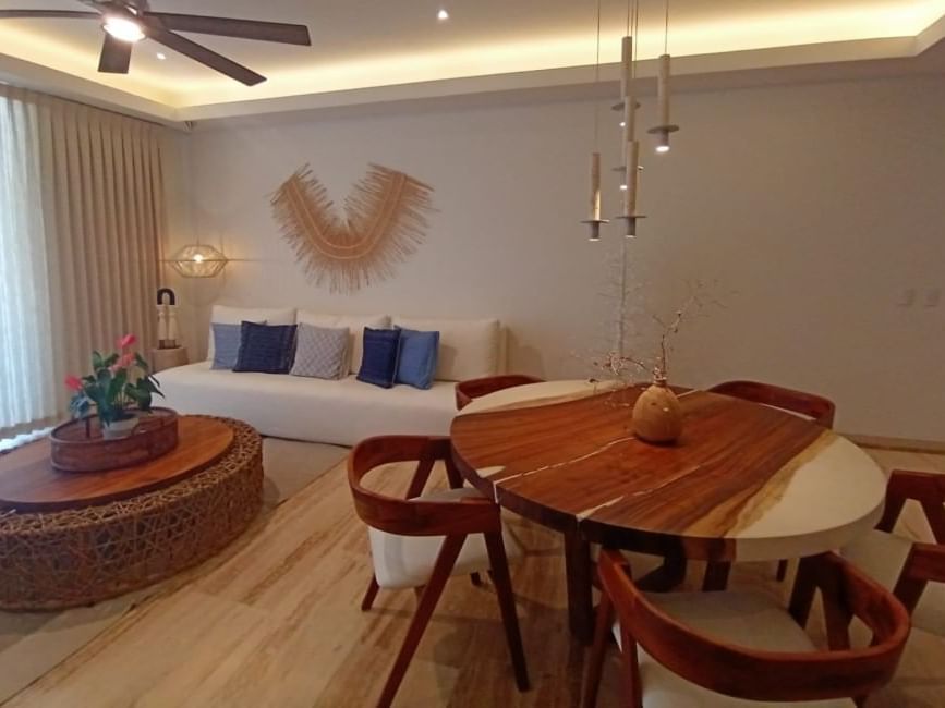 Round dining table, chandelier & comfy sofa in a room at Live Aqua Resorts and Residence Club
