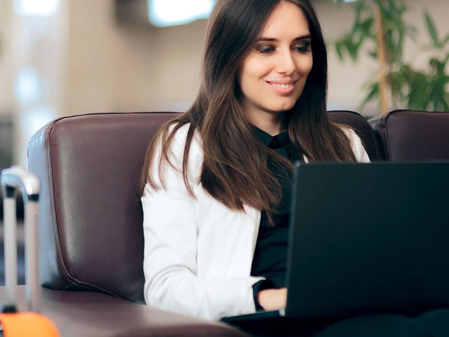 Woman enjoys her laptop on a plush lobby couch providing a comfortable workspace at Paramount Hotel Portland