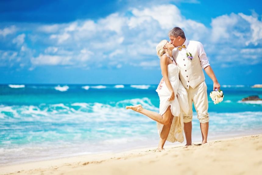 A wedded couple posing by the beach at The Abidah Hotel