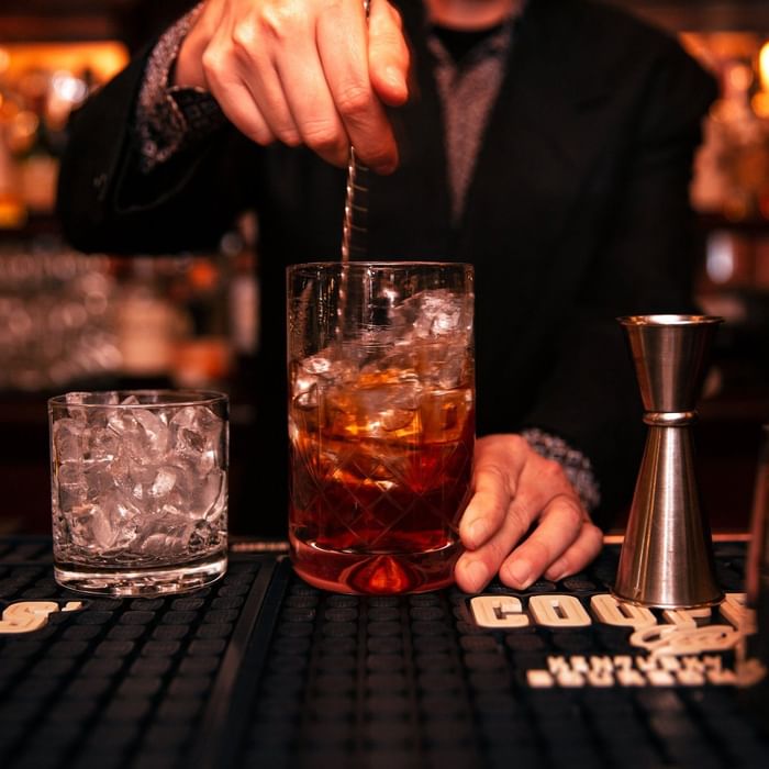 Bartender stirring a cocktail in a glass full of ice in STELLA Bar at Hotel Sorrento