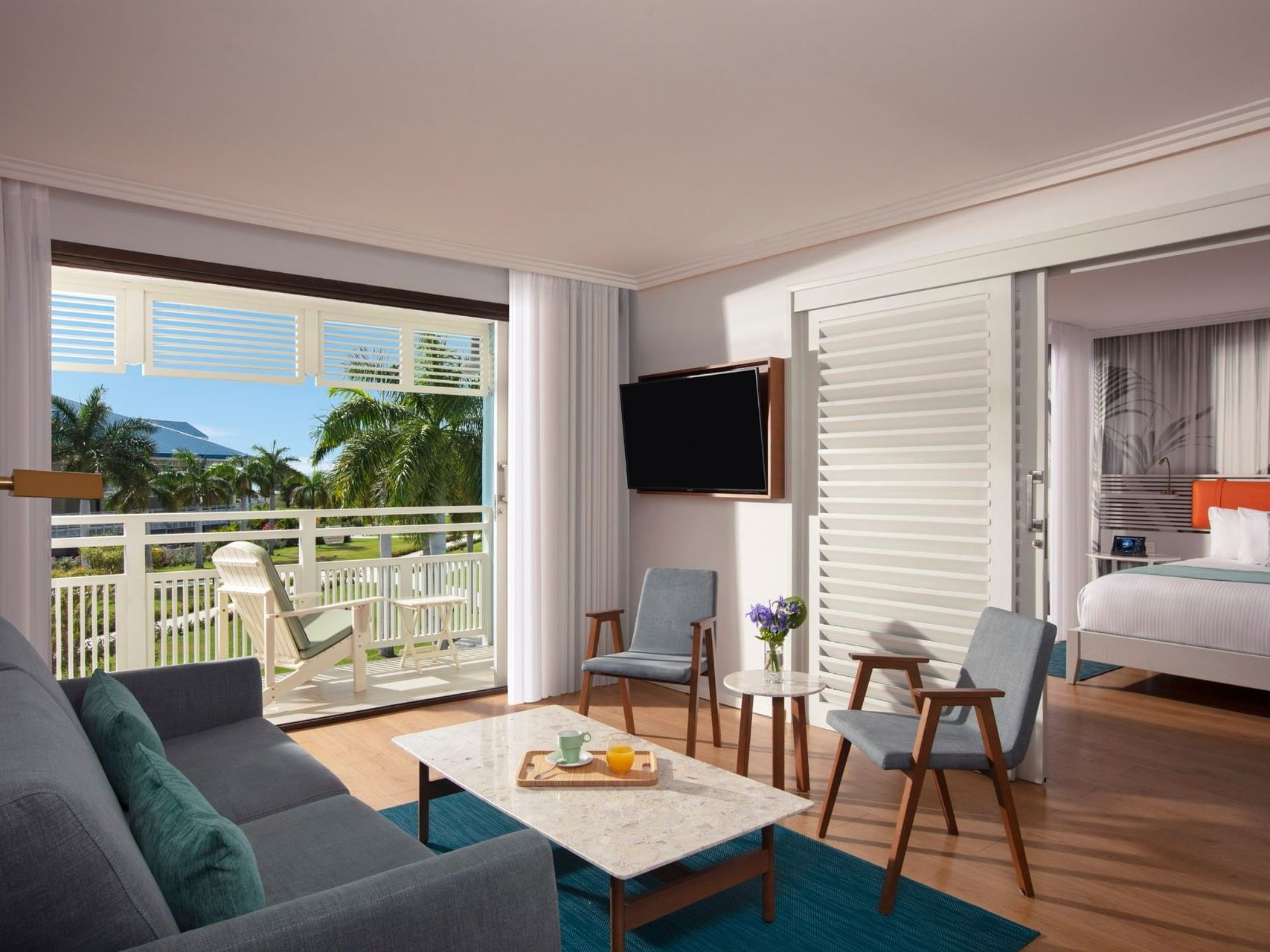 TV lounge area by the bedroom in King Bed Suite Courtyard View with balcony seating area at Saint Martin Beach Resort & Spa