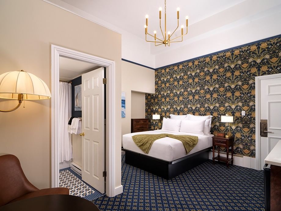Elegant Parlour Room with ornate floral wallpaper, white bedding, and brass chandelier at Belleville House, Pendray Inn collection, Victoria.