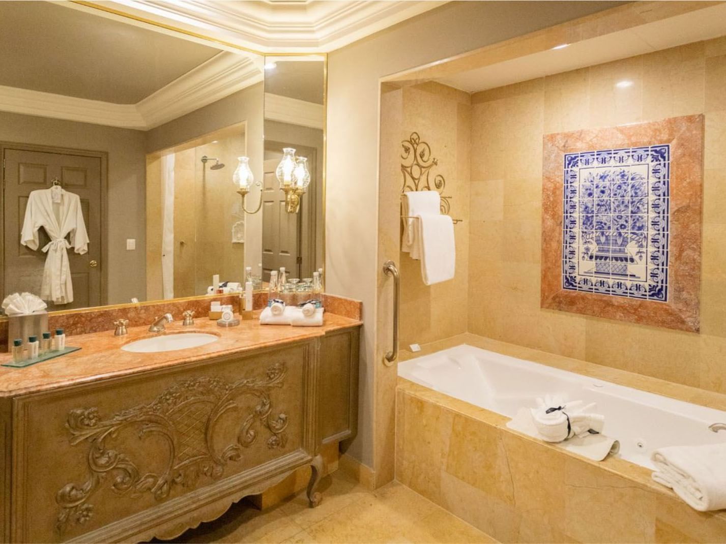 King Grand Class bathroom with a marble vanity, deep soaking tub, and blue tiled artwork at Quinta Real Monterrey