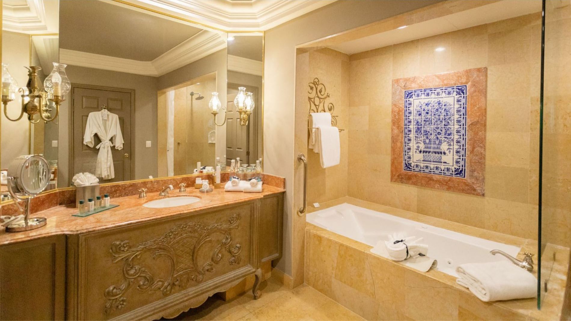King Grand Class bathroom with a marble vanity, deep soaking tub, and blue tiled artwork at Quinta Real Monterrey