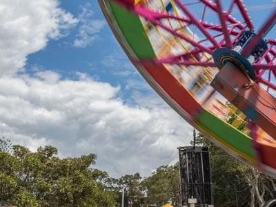 Bright, colorful amusement park ride spinning quickly against a sunny blue sky at Easter near The Sebel Brisbane