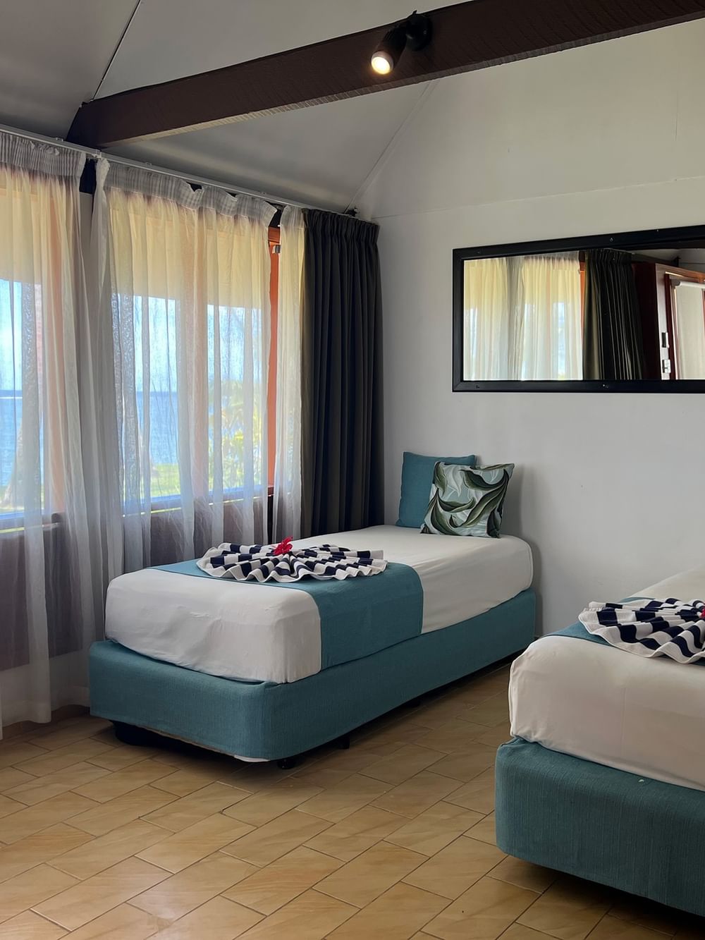 Two beds with ocean view and beach decor at Tambua Sands Beach Resort in Sigatoka.
