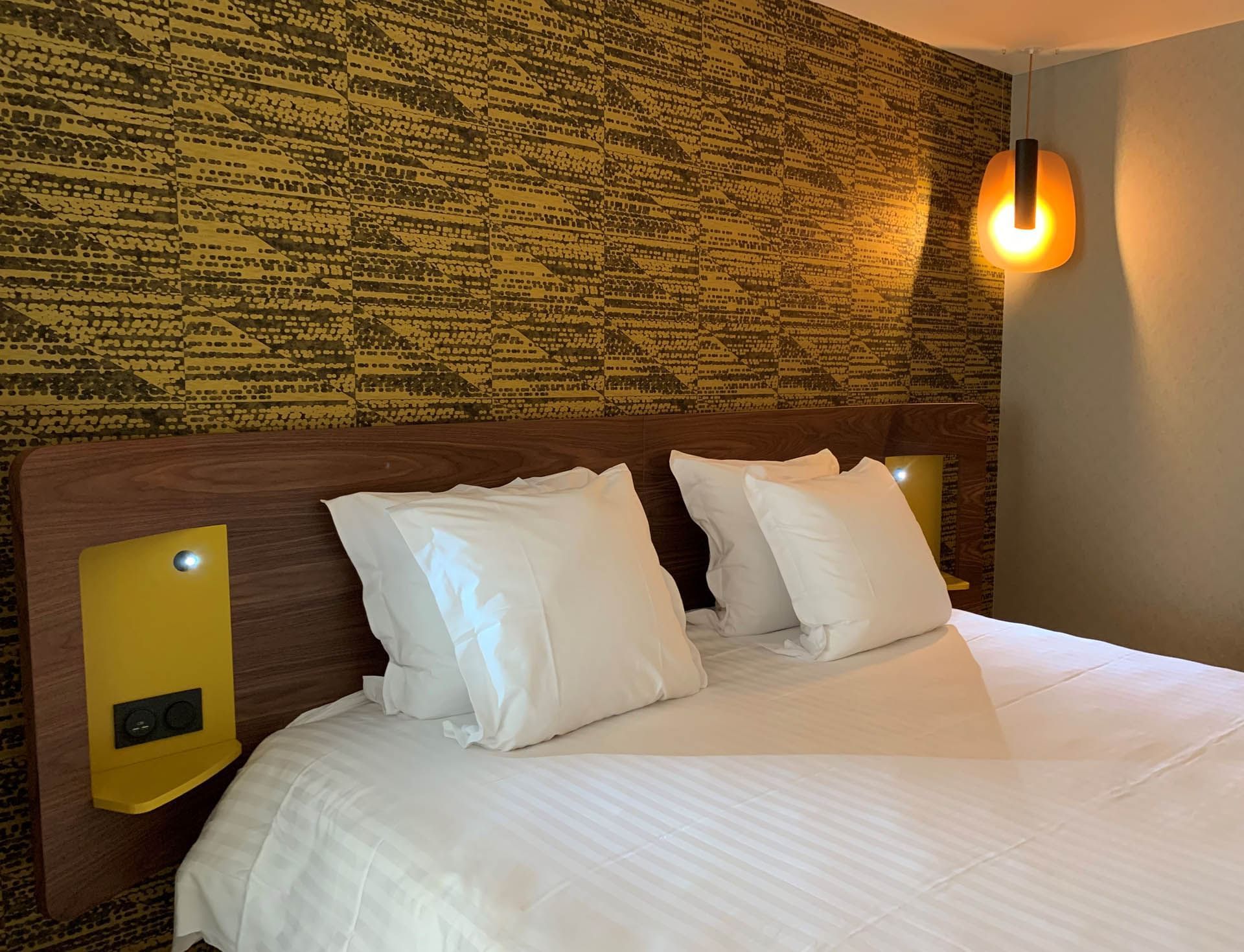 Lit avec décoration murale, lampes, Oceania Paris Porte de Versailles