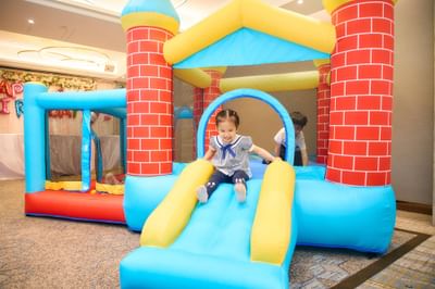Children joyfully bounce on the colorful inflatable castle, one of the fun amenities available at Park Hotel Hong Kong