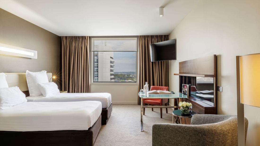 TV with work desk facing bed by the window in Pullman Deluxe Twin Single Room at Pullman Sydney Olympic Park