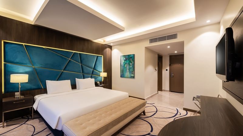 Comfy bed with side tables and TV in Standard Room at Warwick Riyadh