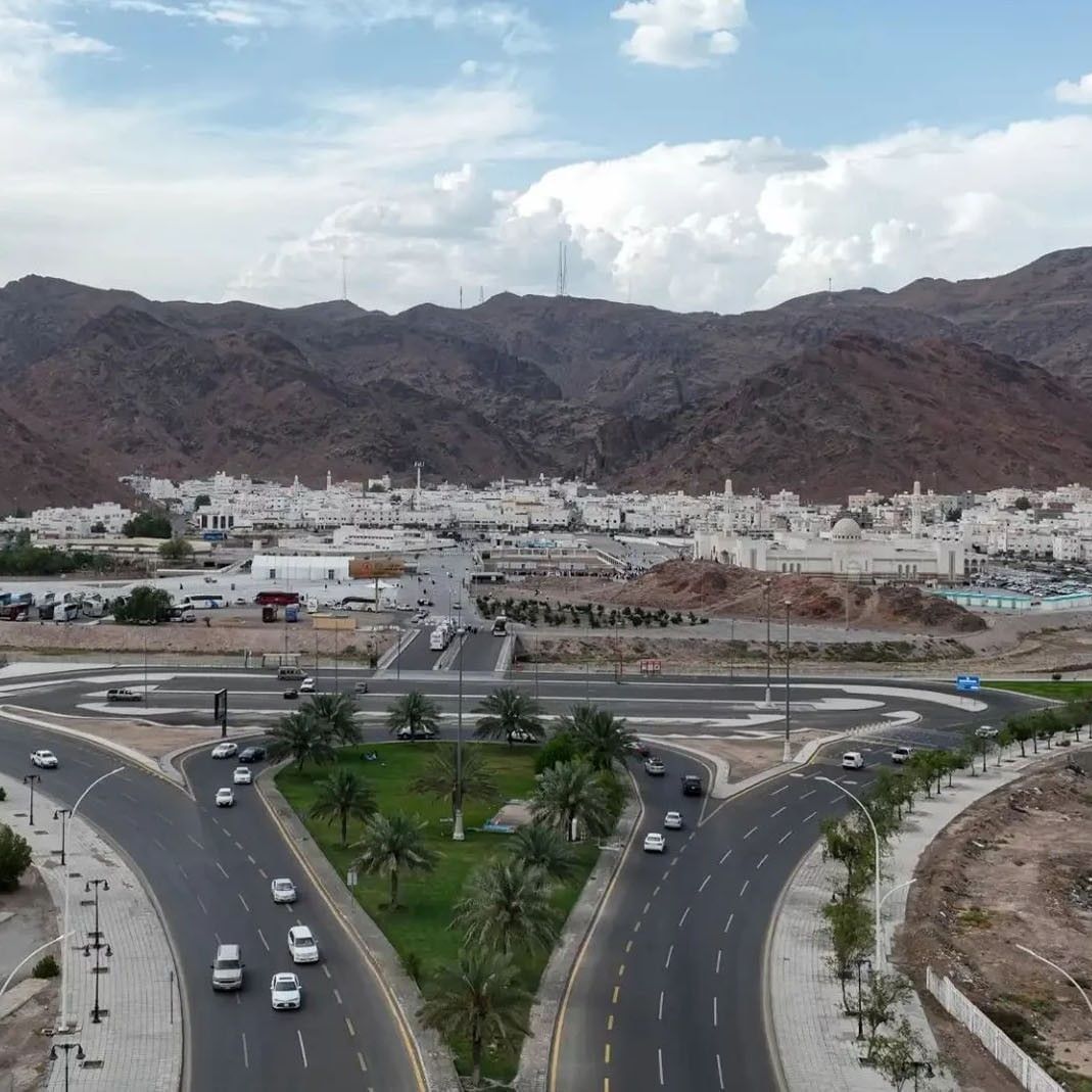 Aerial view of Mount Uhud with palm trees & mountains, and white buildings at Saja Warwick Madinah