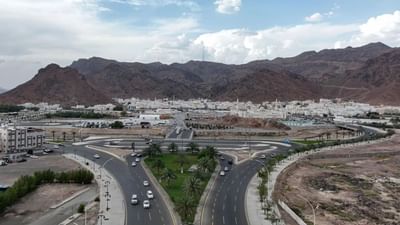 Aerial view of Mount Uhud with palm trees & mountains, and white buildings at Saja Warwick Madinah