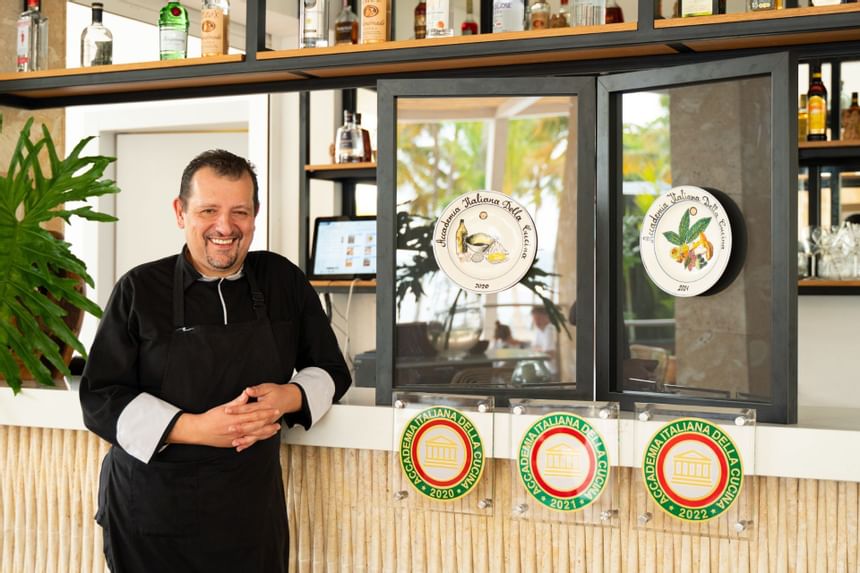 A bartender smiling in front of the bar at Club Hemingway