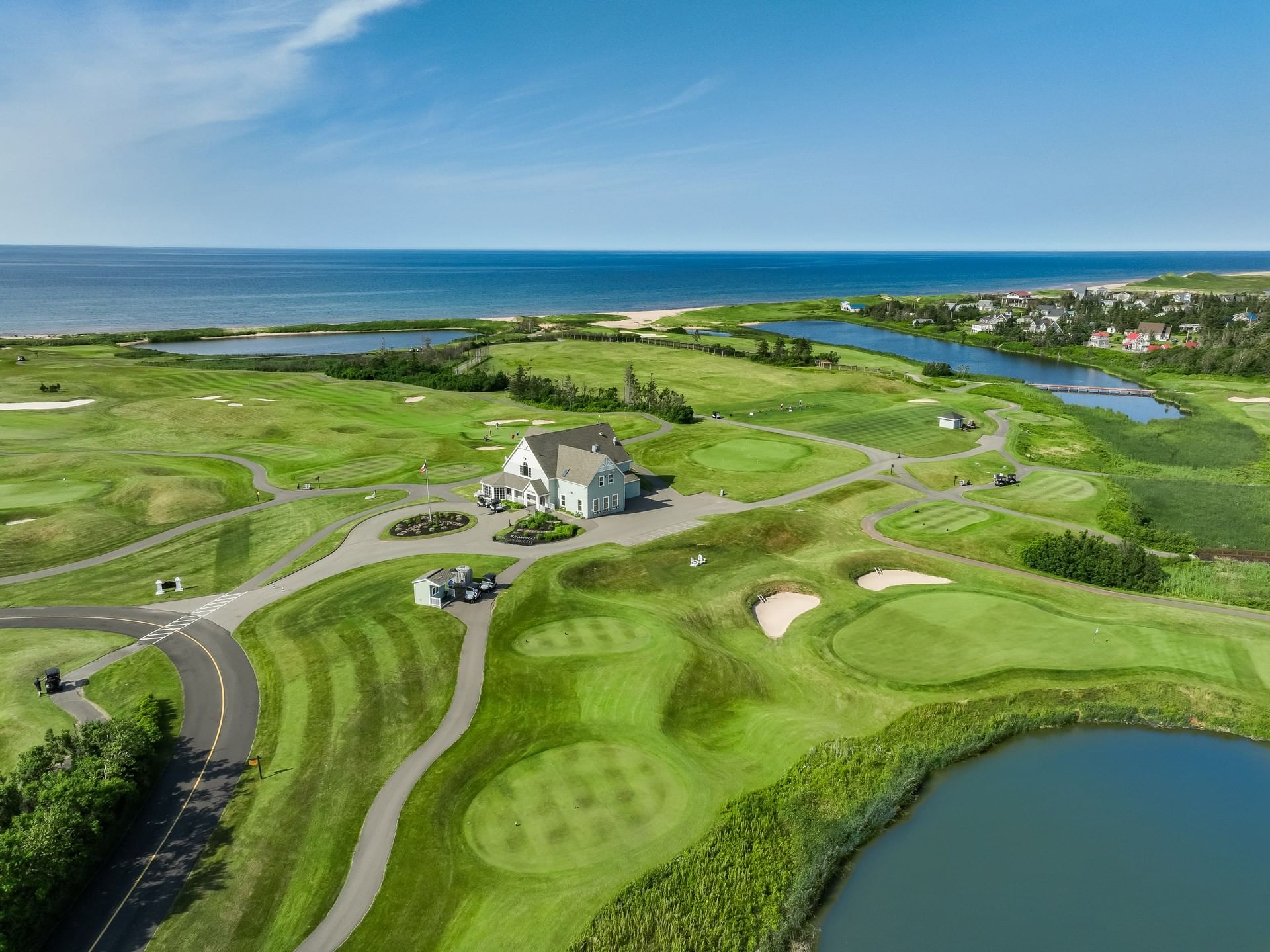 Aerial view of the clubhouse and several golf greens, a top golf resort in PEI, Canada, at Rodd Crowbush Golf & Beach Resort