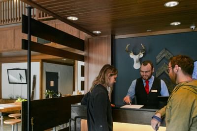 Guests checking in by the reception desk at Adara Hotel