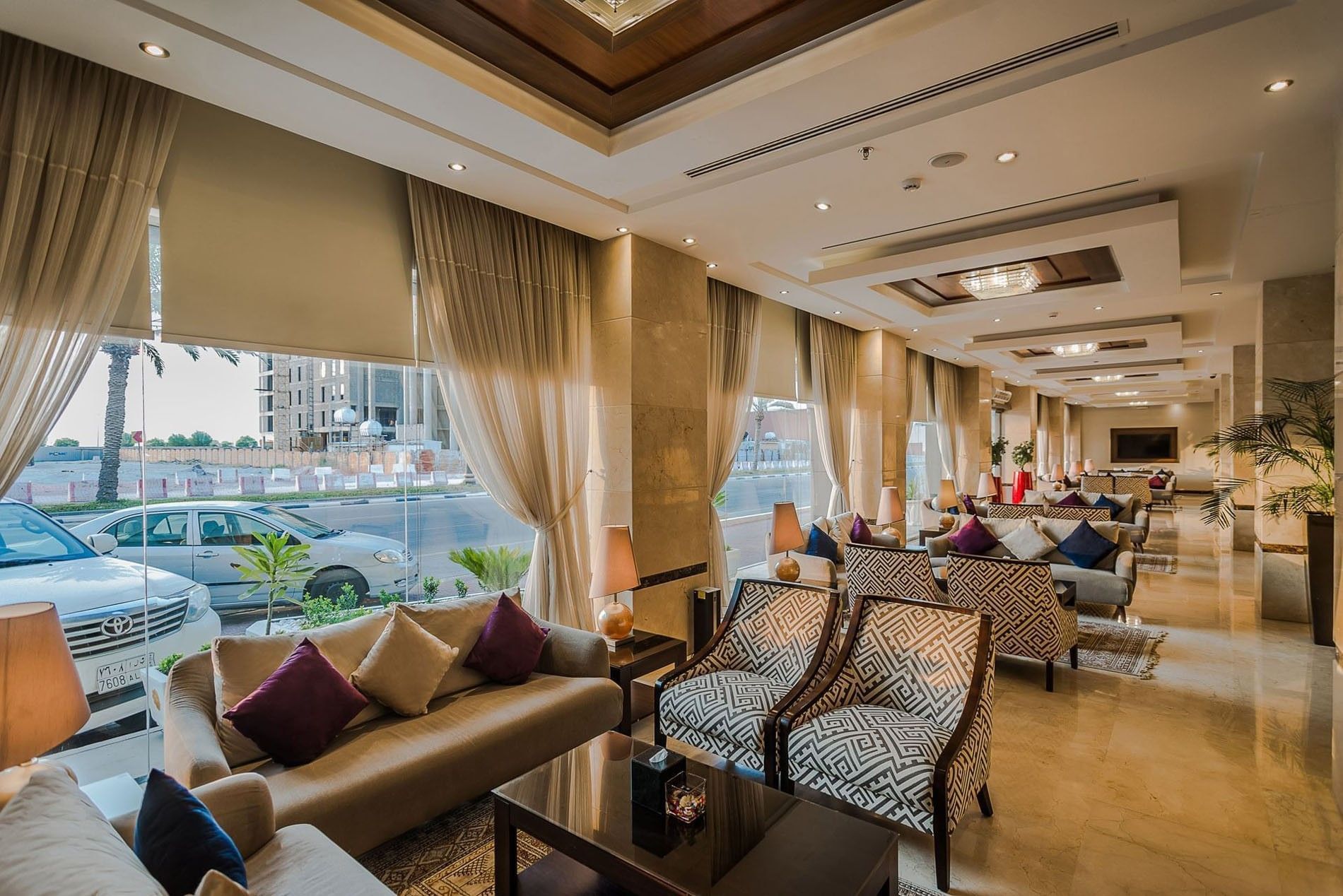 Stylish lobby featuring patterned armchairs and beige sofas under soft lighting at Naviti by Warwick Al Khobar