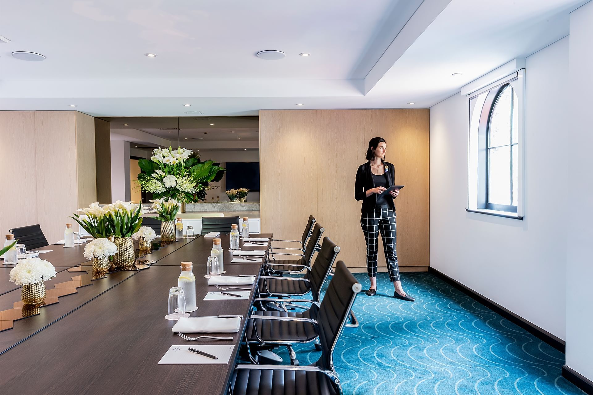 Lady in a Meeting Room with an arranged Boardroom table at Novotel Sydney Darling Square