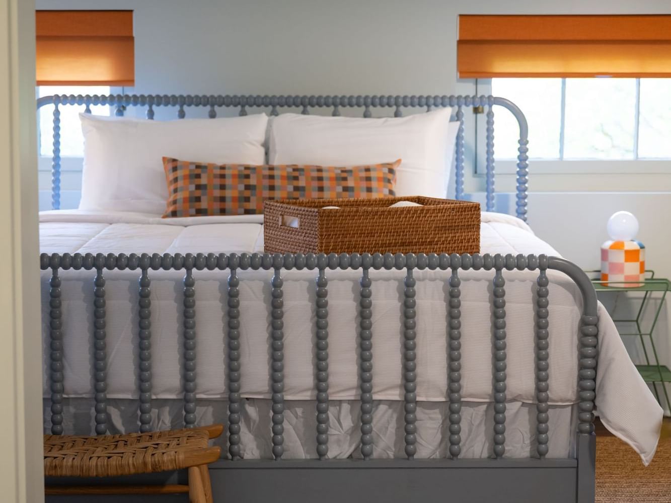 Classic King Room with cozy bed, nightstand, and wicker basket at The Ashbrook Hotel in Frankfurt, Kentucky.