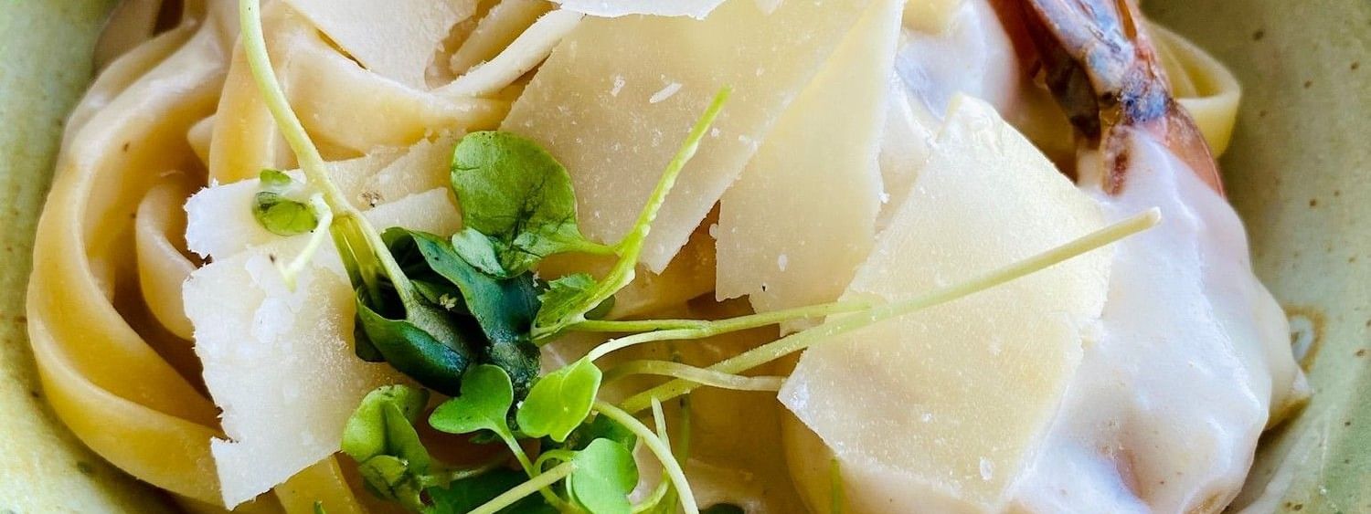 Creamy pasta with fresh greens under shaved cheese in Edgewater Grill at Warwick Paradise Island Bahamas