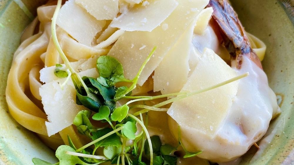 Creamy pasta with fresh greens under shaved cheese in Edgewater Grill at Warwick Paradise Island Bahamas