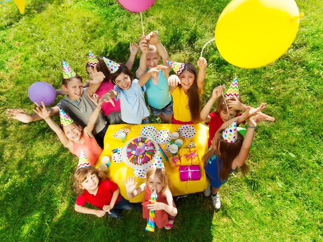 Group of laughing kids standing around the cake, Grand Coloane