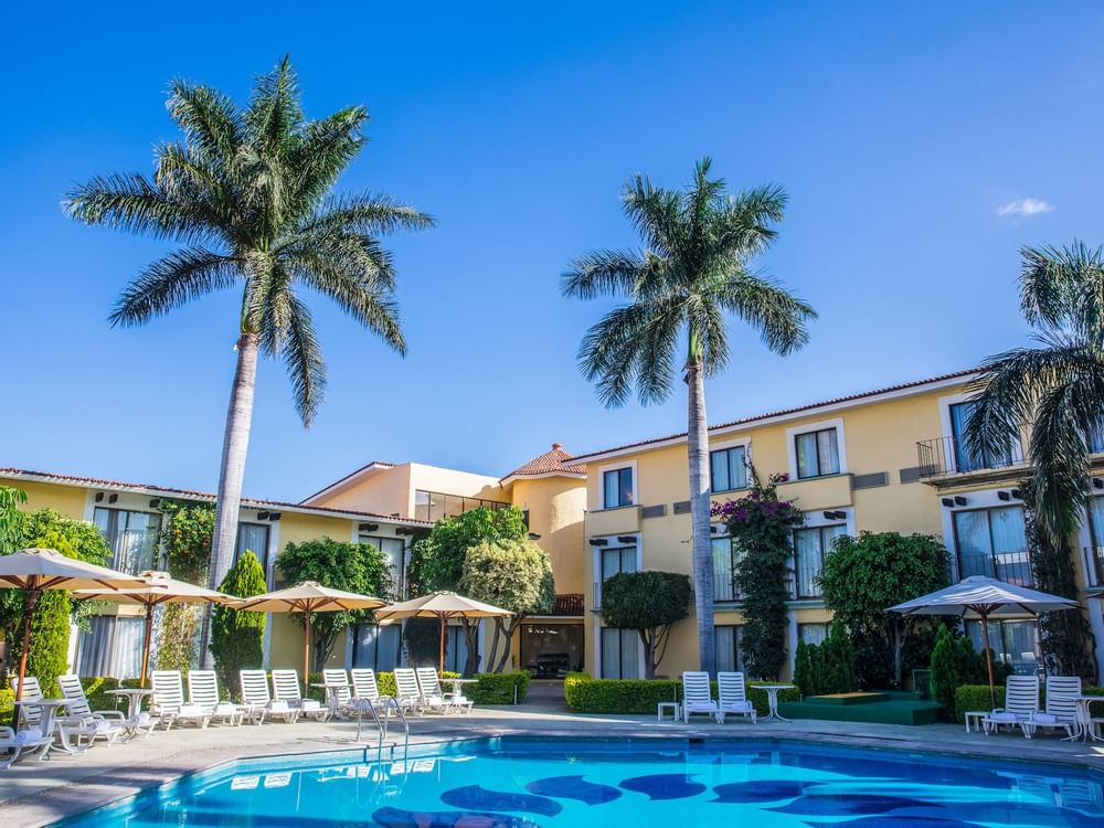Outdoor swimming pool with loungers at Fiesta Inn Hotels