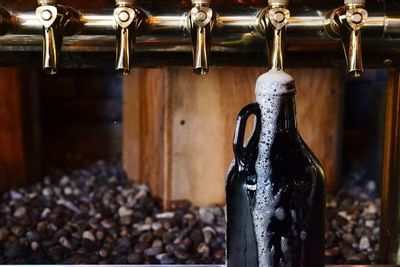 Growler being filled with fresh, craft beer from the taps at the Swine Moonshine + Whiskey Bar at Paramount Hotel Portland