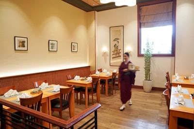 Waitress by the Restaurant dining tables at Hanoi Daewoo Hotel