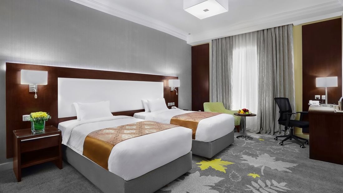 Twin beds and working area in Superior Room with carpeted floors at Warwick Hotel Jeddah