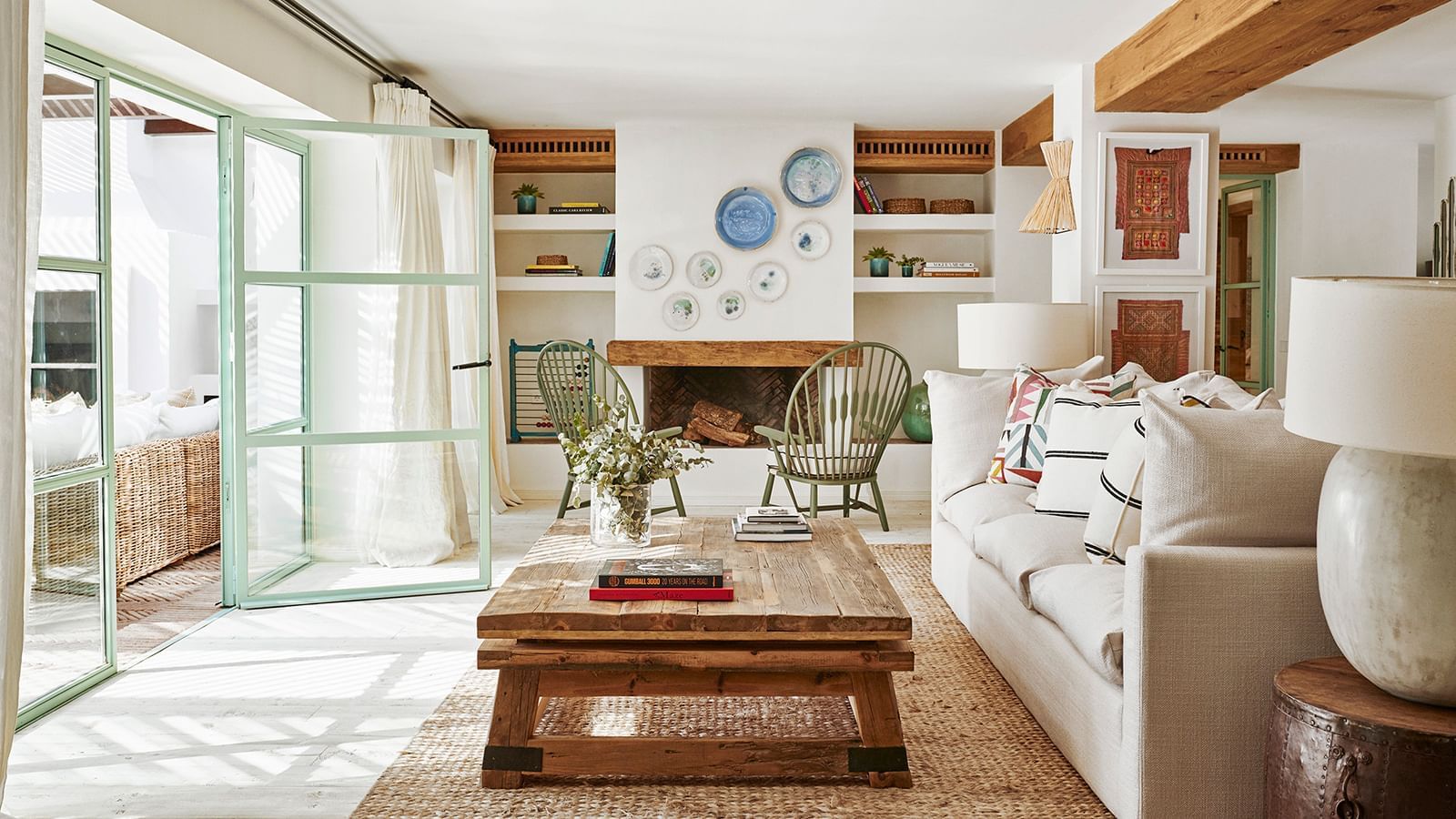 Living area with a wooden coffee table on a jute rug, near a sofa and fireplace at the Marbella Club