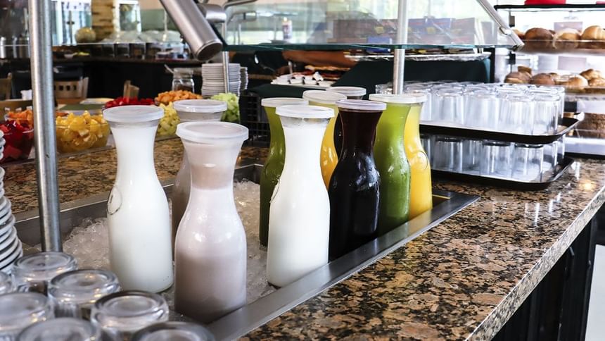 Jarras de vidrio con jugos y leche enfriadas en hielo sobre granito en La Pérgola de Araiza Palmira 