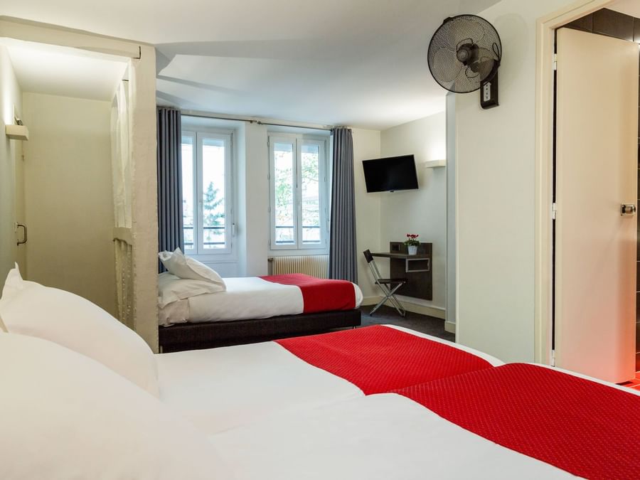 Interior of a bedroom with a comfy bed at Hotel Lecourbe