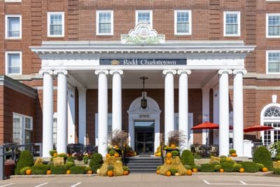 Pumpkins arranged on straw bales by large pillars at Rodd Charlottetown Hotel, an apartment hotel in PEI