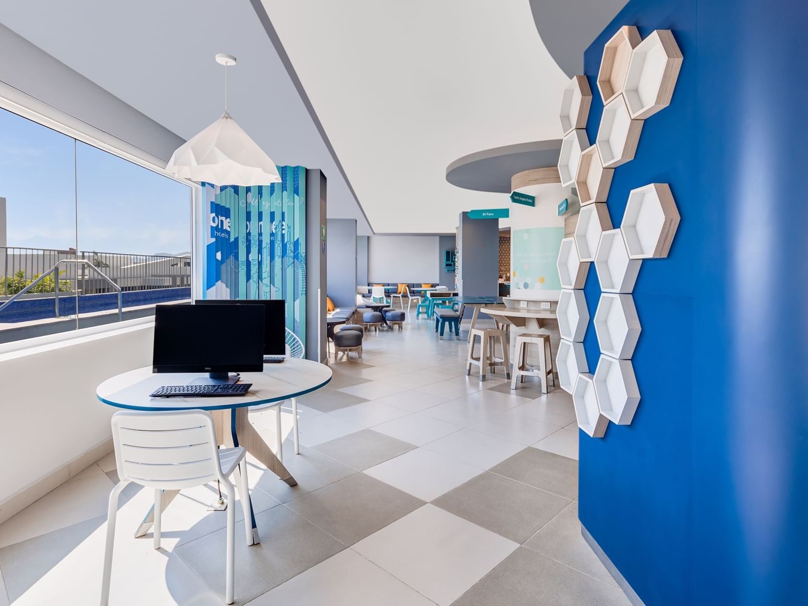 Blue color themed Business Center arranged with seating at One Hotels
