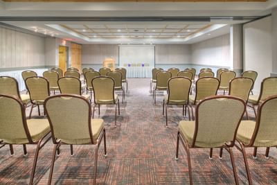 Pine Room with arranged chairs and a screen at Fairmont Hot Springs Resort