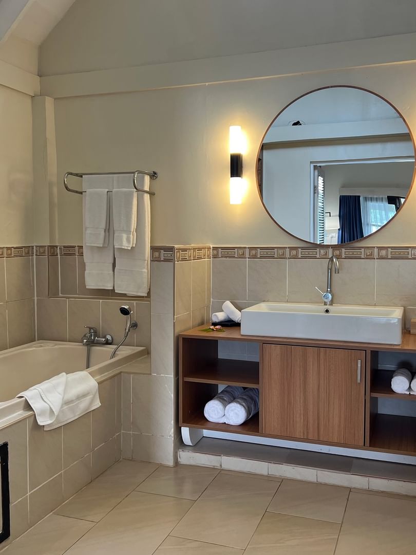 Clean Lagoon Bungalow bathroom with a bathtub, vanity, and towels at Warwick Le Lagon - Vanuatu in Efate.