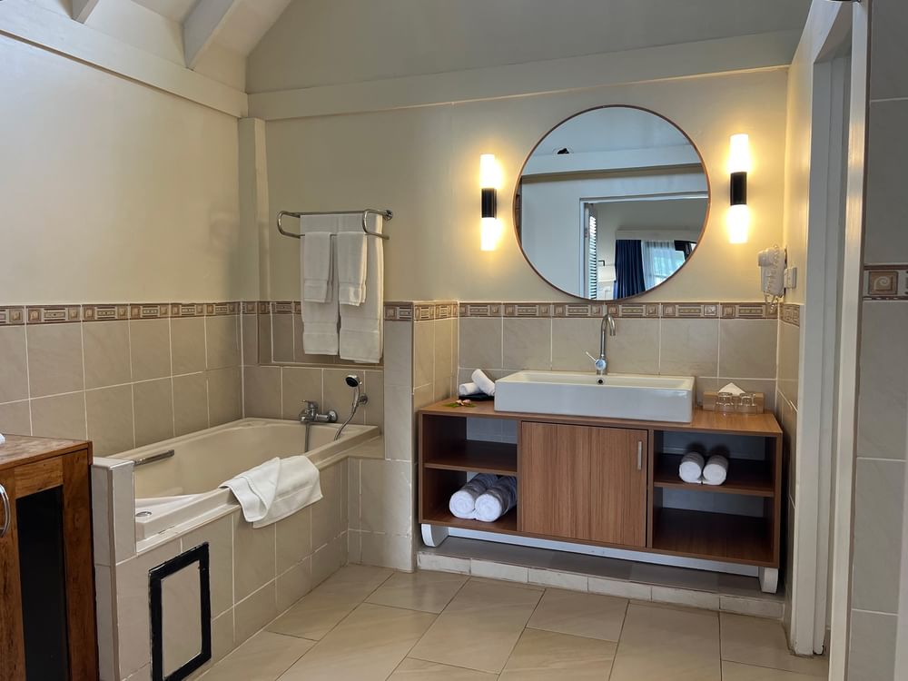 Clean Lagoon Bungalow bathroom with a bathtub, vanity, and towels at Warwick Le Lagon - Vanuatu in Efate.