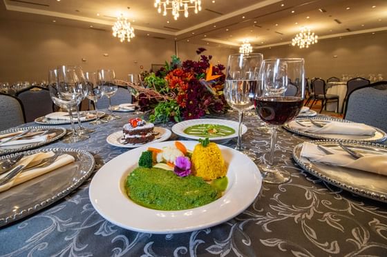 Gourmet dinner with wine glasses by a floral centerpiece at Mirra, hotel with meeting rooms in San Luis Sonora for events