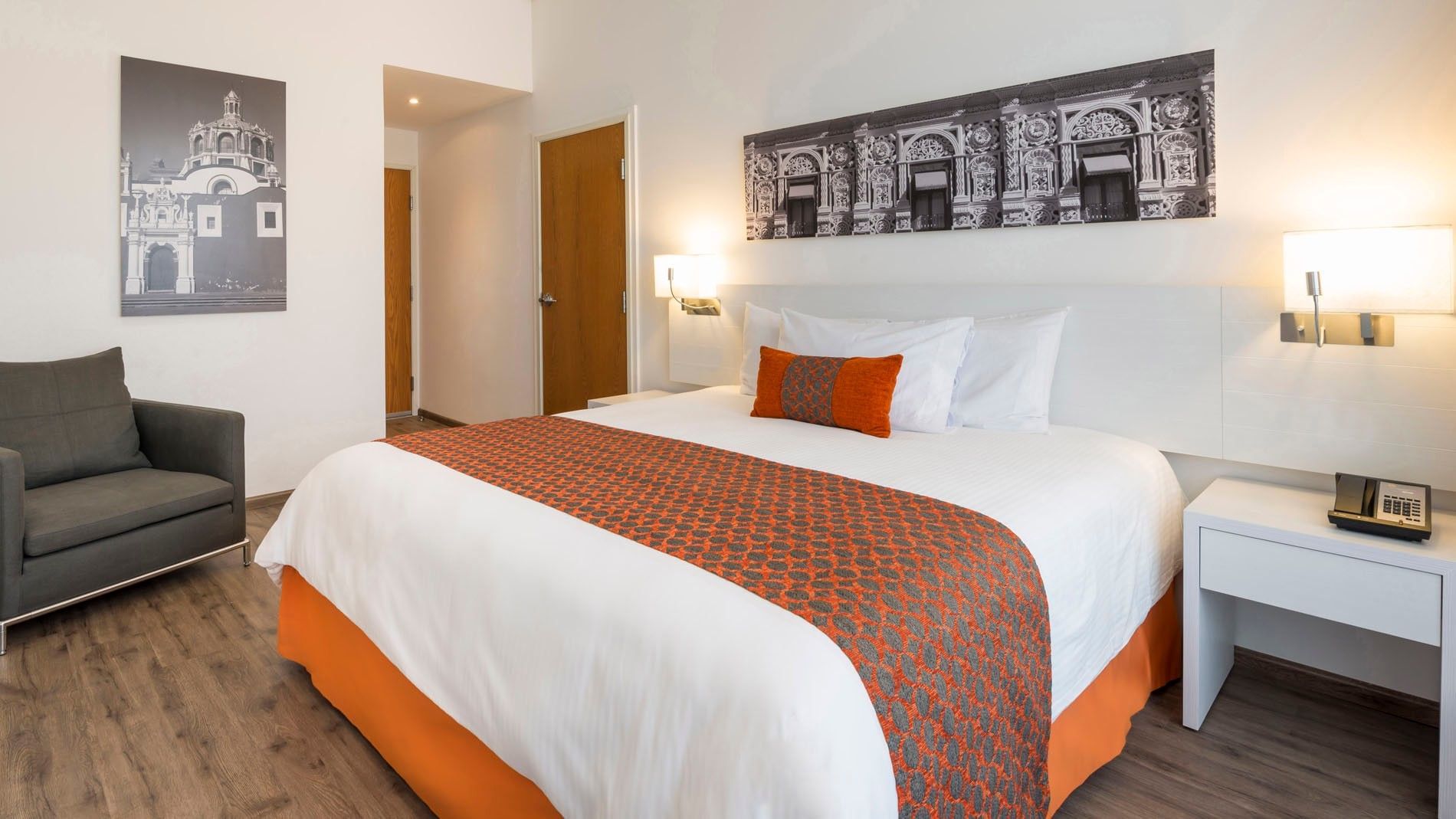 King Standard room featuring a plush bed and stylish wooden door entry area at Camino Real Puebla Angelopolis