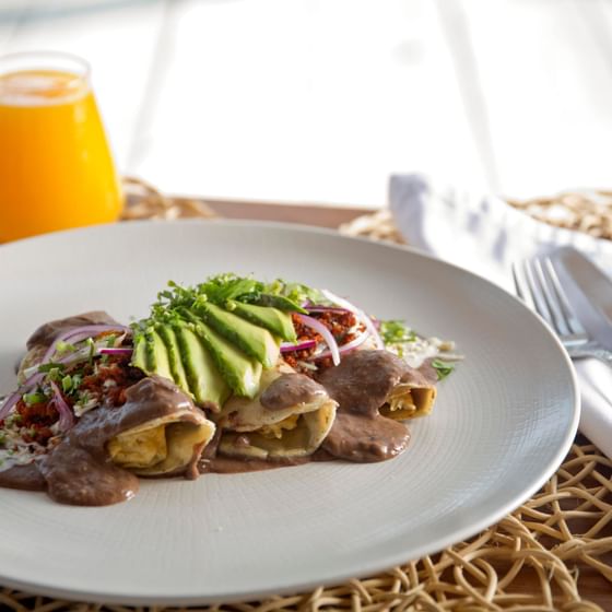 Enfrijoladas dish served with juice at Marea Beachfront Villas