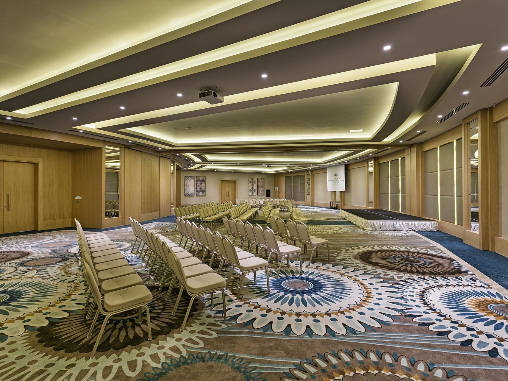 A modern and stylish conference hall with floral-patterned carpet at Titanic Luxury Collection Bodrum.