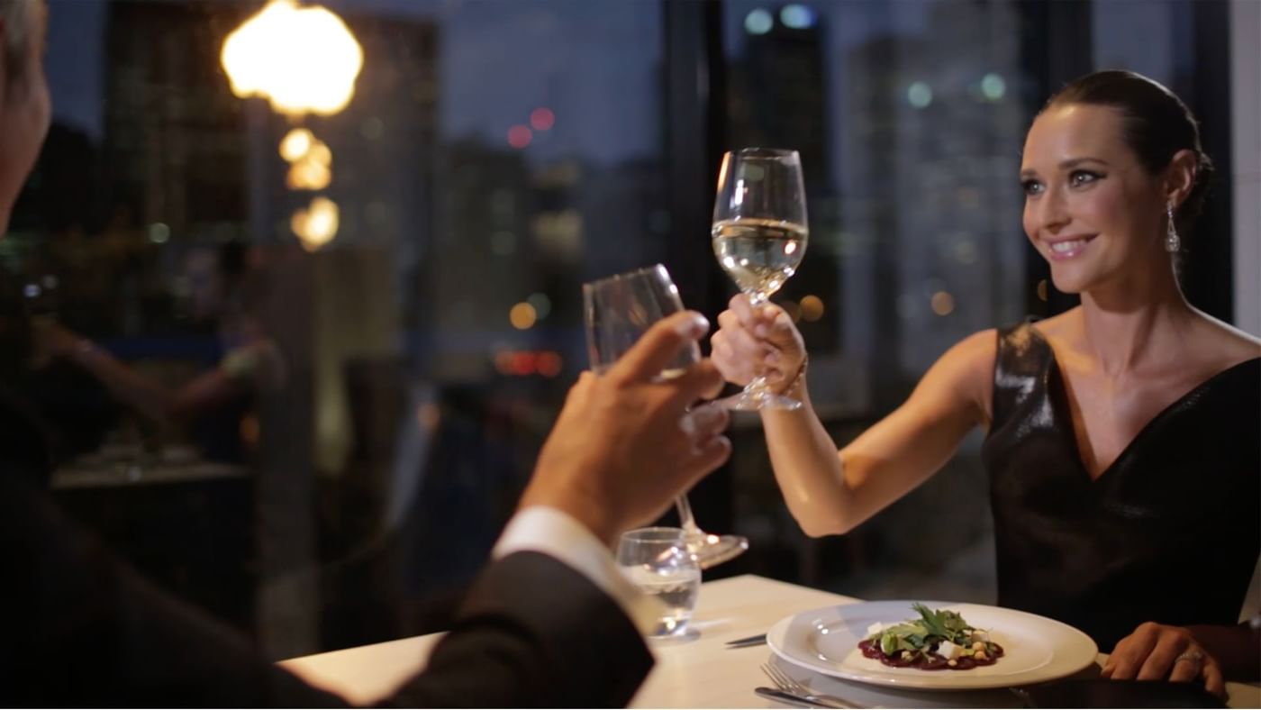 A couple toasting with wine glasses at Crown Hotels