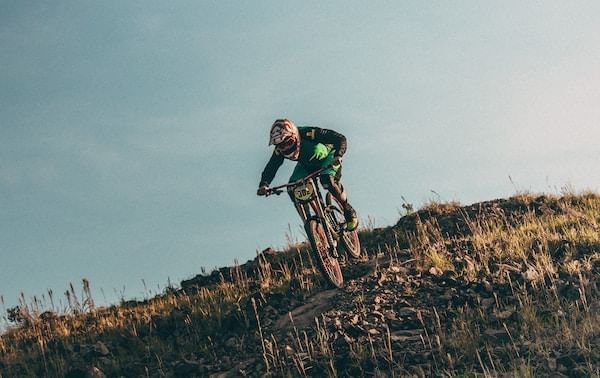 Man riding a bike down a hill near Blackcomb Springs Suites