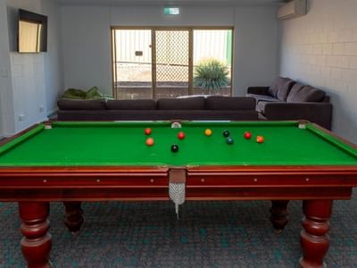 Green pool table with balls and a couch in a room at La Trobe University - Orde House.