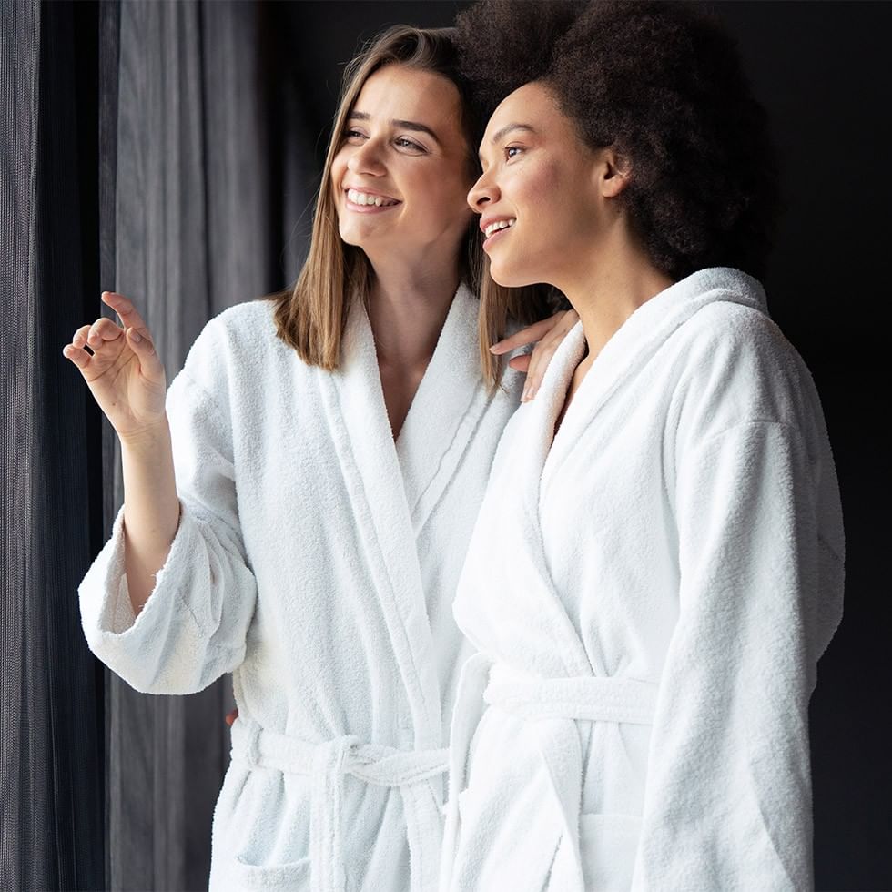 Dvije žene u bijelim kupaćicam robe u ponudi.