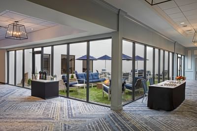 Indoor pre-function lobby and registration area with courtyard glass view at Sable Oaks Weddings and Events