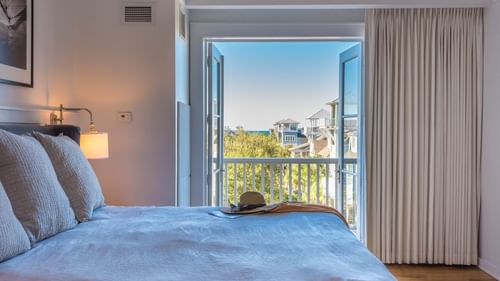 Comfy bed with balcony view in Premium Resort Suite at Watersound Inn